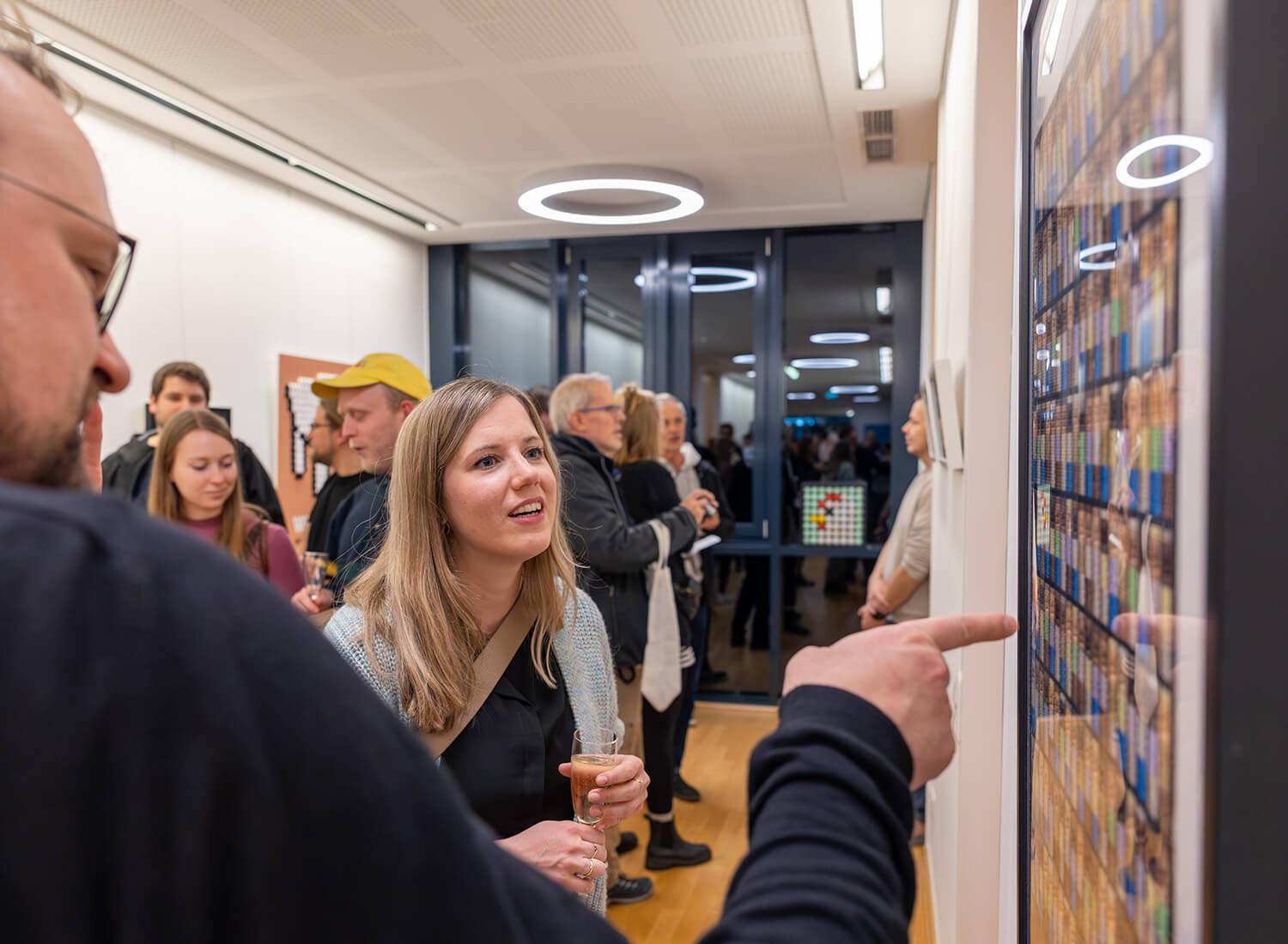 Eine Person zeigt auf eine besondere Stelle in einem Werk in dem kleine Spiegel verwendet wurden Eine Person zeigt auf eine besondere Stelle in einem Werk in dem kleine Spiegel verwendet wurden