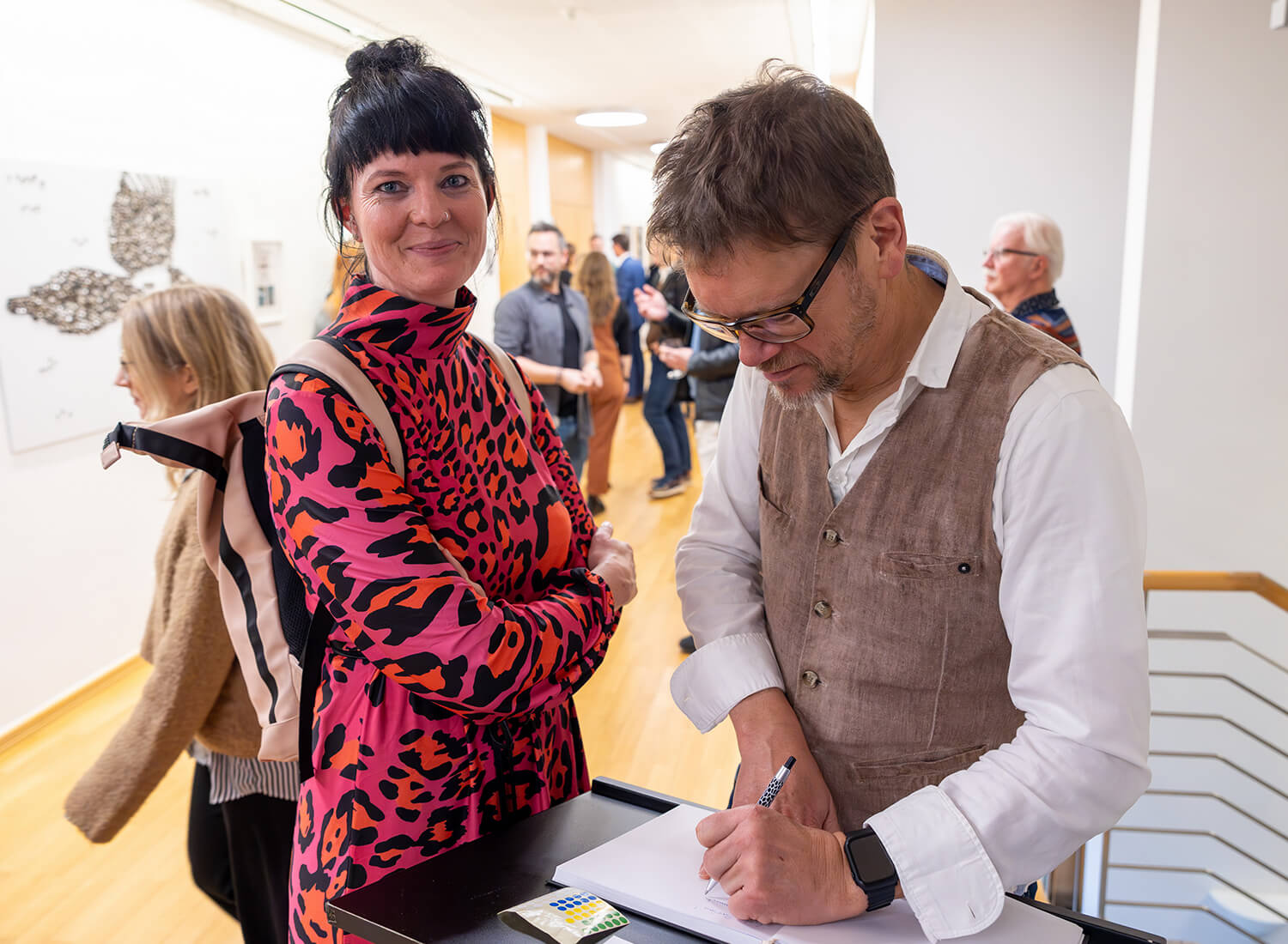 Zwei Besucher verewigen sich im Gästebuch der Vernissage Zwei Besucher verewigen sich im Gästebuch der Vernissage